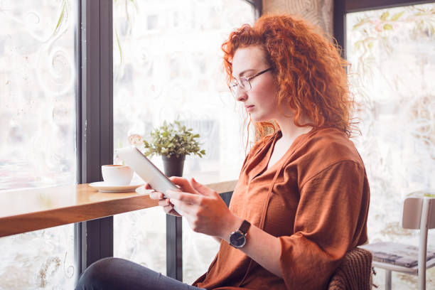 istock Young woman with digital tablet drinking coffee 1132038893