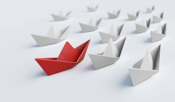 Red paper boat in front of others. Leadership and difference concept. 3D rendered illustration.