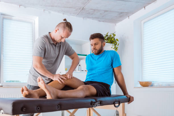 istock Physiotherapist massaging young man's legs 1132044652