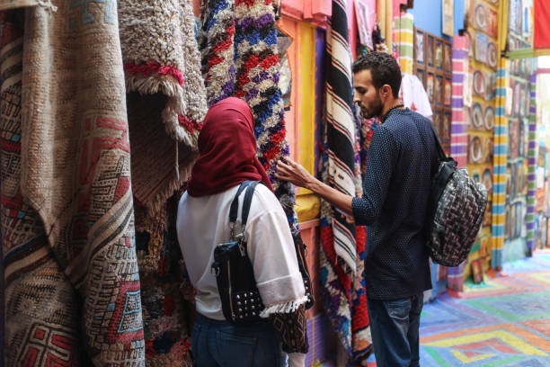 Arab couple looking at carpets Arab couple looking at carpets. Both about 25 years old, Middle Eastern people. moroccan woman stock pictures, royalty-free photos & images