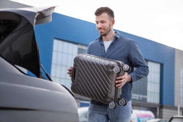 istock Man putting a suitcase in a car trunk 1132044774