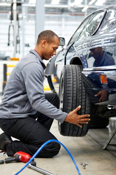 istock Young engineer adjusting car tire in showroom 1132044849