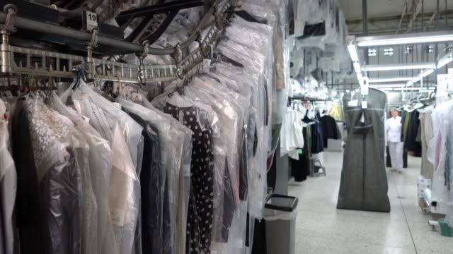Clean garments on conveyor belt at an industrial dry cleaning service