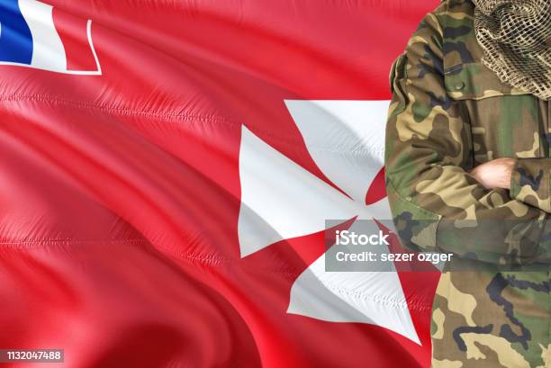 Crossed Arms Soldier With National Waving Flag On Background Wallis And Futuna Military Theme Stock Photo - Download Image Now