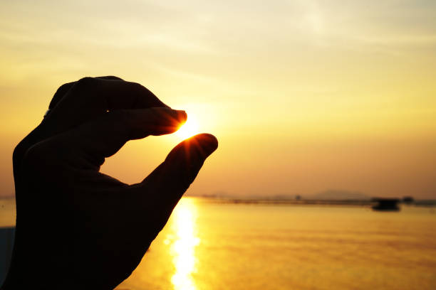 istock Hand holding the sun in the sunset 1132051258