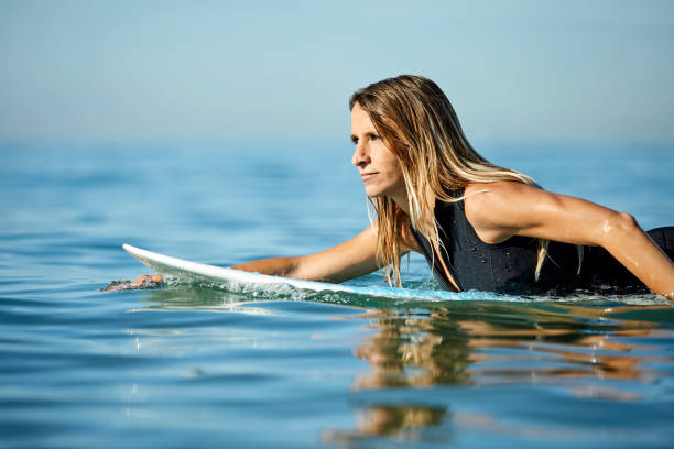 istock Determined woman looking away while surfing in sea 1132054059