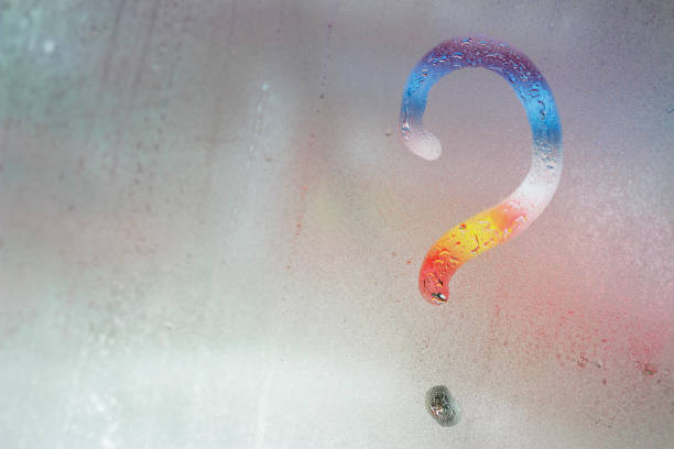 istock multicolored question mark on the window glass background, toned 1132056193