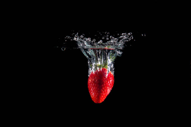 istock Fresh Strawberries with water splash over black background 1132056812