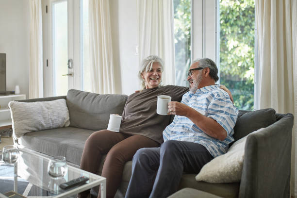 istock Happy elderly couple relaxing on sofa at home 1132057491