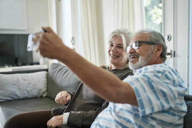istock Senior man taking selfie with woman at home 1132057513