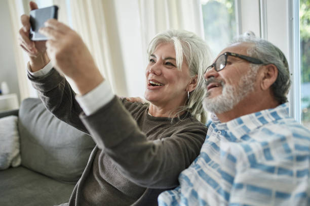 istock Senior woman taking selfie with man at home 1132057585