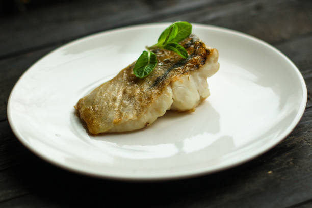 рыба, жареные морепродукты (белая рыба на тарелке). продовольственная фон - sea bass prepared fish food grilled стоковые фото и изображения