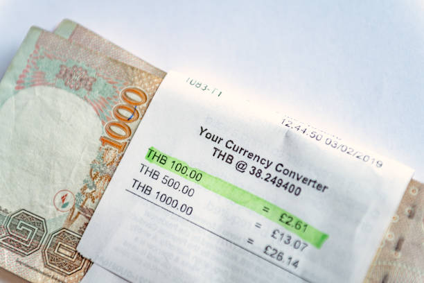 istock Thailand baht notes on a plain white background wrapped in the exchange rate receipt 1132058144