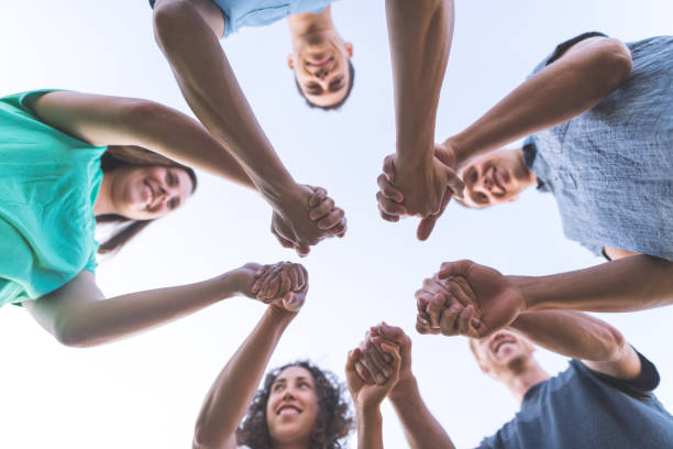 istock Low angle shot of multiethnic group holding hands 1132058680