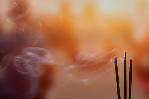 Quema de incienso palos con humo, palos de Joss quema en un templo budista de época. Concéntrese en el palo de incienso y humo. photo