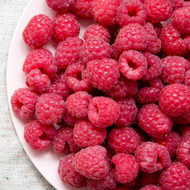istock Raspberry on a plate on cloth, overhead view. Flat lay, overhead, from above. Closeup. 1132059624