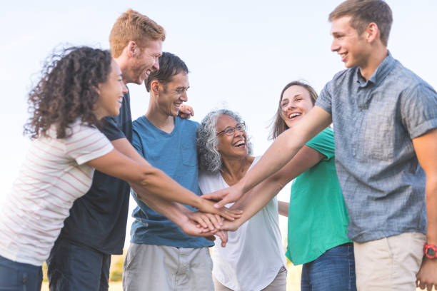 istock Multiethnic group of adults puts their hands together for a cheer 1132059807