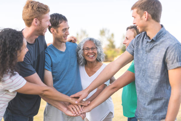 istock Multiethnic group of adults puts their hands together for a cheer 1132059812