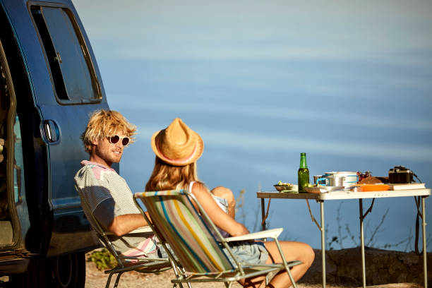 istock Couple sitting on chairs by mini van 1132059855