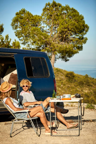 istock Man and woman enjoying picnic by mini van 1132059873