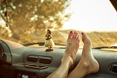 Close-up of woman's feet on dashboard of mini van