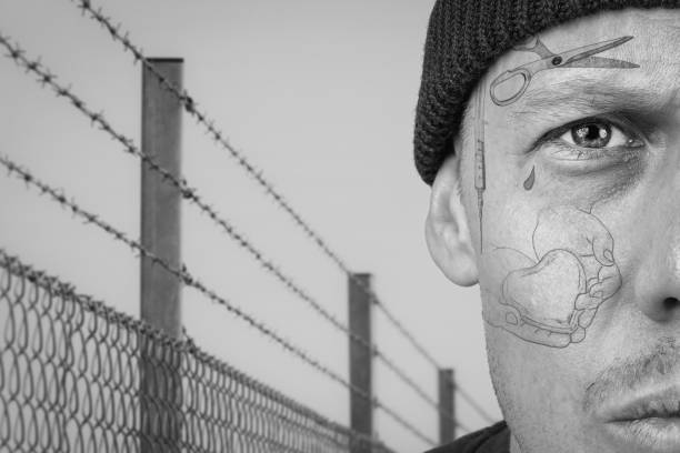 Portrait of guy with teardrop and face prison tattoo. stock photo
