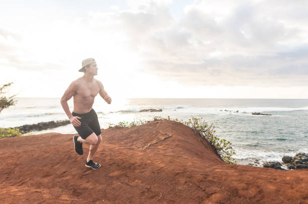 istock Shirtless jogger running along the wild Hawaii coastline 1132061107