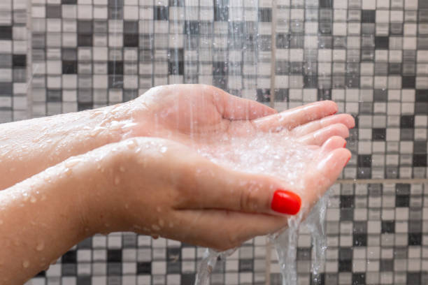 istock Soft selective focus of hands and droplets of water from shower with pattern background 1132061312