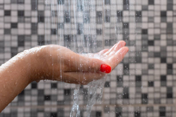 istock Soft selective focus of hands and droplets of water from shower with pattern background 1132062089
