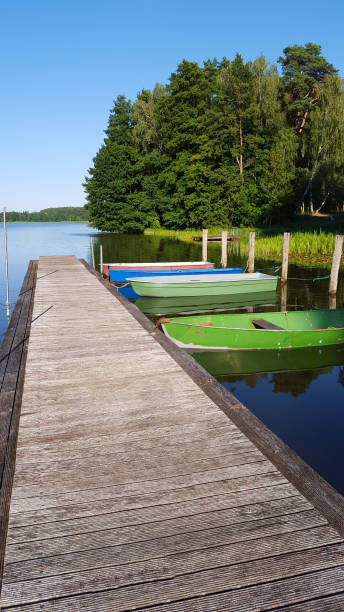 istock Colored boats on a dock or jetty at a lake 1132068014