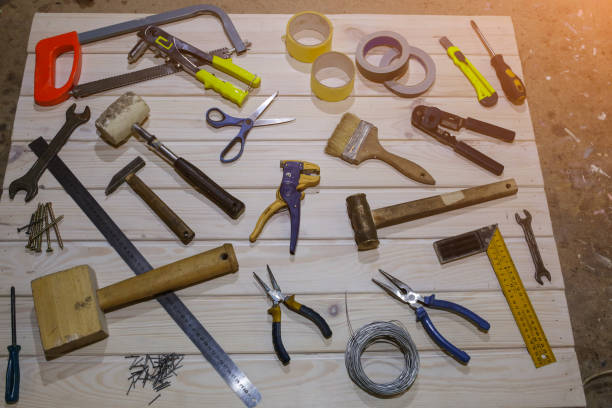 istock Working instruments lying on the wooden board. Scissors, scotch tape, pliers, brushes are used for maintenance repairing works. 1132068711