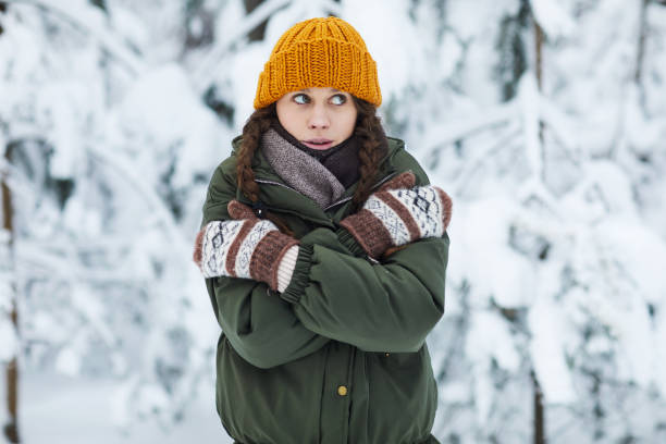 Young Woman Freezing in Winter Waist up portrait of pretty young woman freezing in cold winter forest, copy space woman defeat stock pictures, royalty-free photos & images