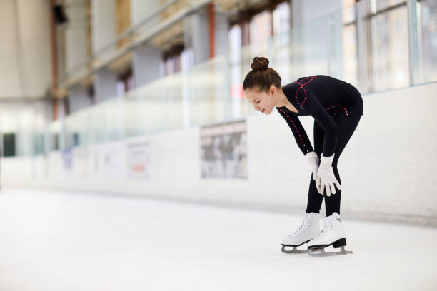 Injury on Ice Rink Full length portrait of injured girl on skating rink during practice, copy space physical injury sport ice pain stock pictures, royalty-free photos & images