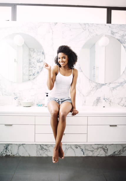 Shot of an attractive young woman brushing her teeth in the bathroom at home