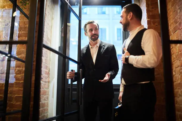 Portrait of two handsome gentlemen entering cafe, copy space