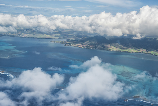 Flying over island Mauritius with beautiful sight over coastline, archipelago and cloudscape.