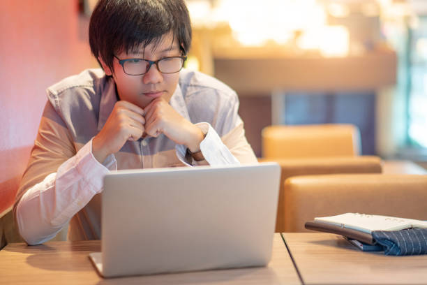 istock Asian businessman using laptop computer in the cafe thinking about business work solution. Smart working with online social network. Internet of things concepts 1132079483