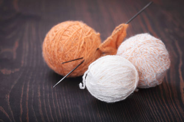 Skeins of wool thread for knitting on a wooden background.