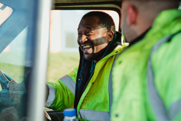 Family Business Fun Senior man and his son are laughing and talking together in their work van. driver occupation photos stock pictures, royalty-free photos & images