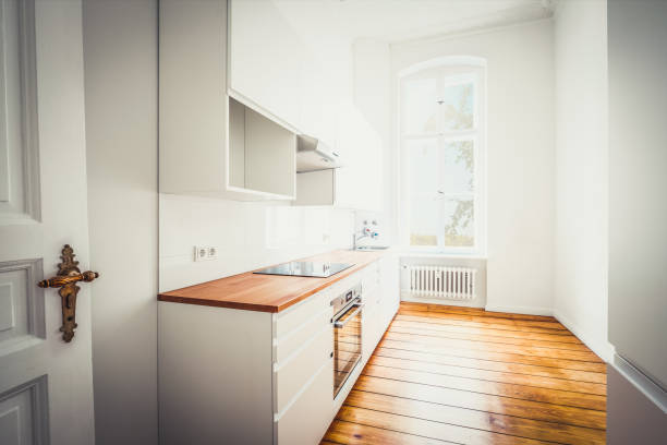 vazio, nova built-in cozinha com móveis brancos e piso de madeira - home studio - fotografias e filmes do acervo