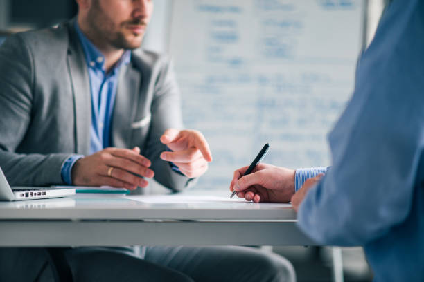 Business people negotiating, signing a contract, close-up.