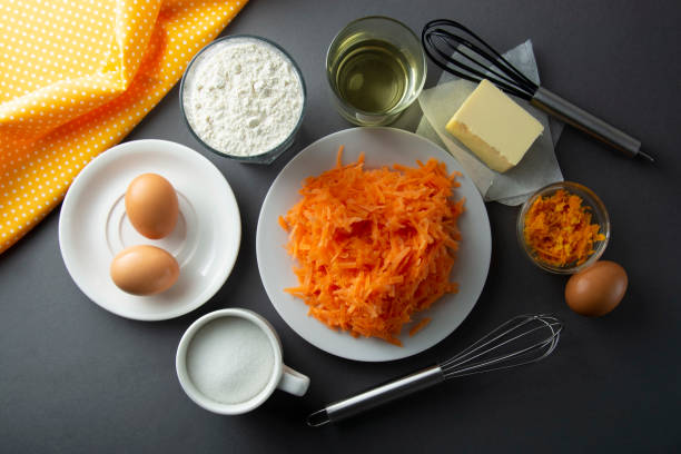 рецепт морковного торта. изготовление теста для морк�овного торта, пирога, кексов или пирога, на кухонном столе - яйца, мука, масло, апельсин, � - cake carrot carrot cake dessert стоковые фото и изображения