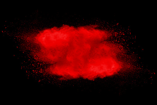 Stopping the movement of red dust on black background.