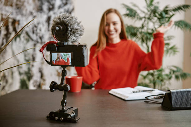 I want your likes! Portrait of cheerful young broadcasting a new tutorial for her vlog with tripod mounted digital camera
