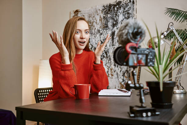 istock Shock news! Surprised female blogger is gesturing while creating a new video and speaking on camera 1132090143