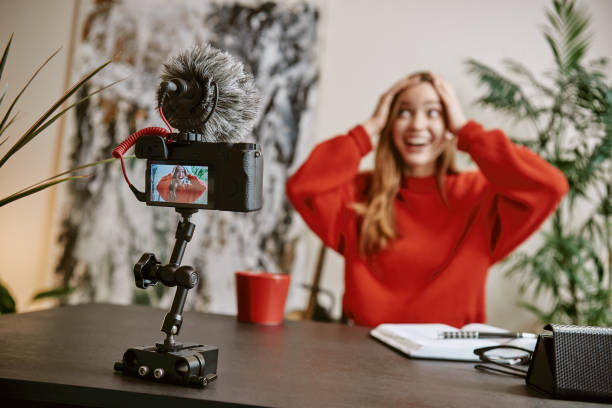 istock Fantastic news! Surprised female blogger is touching a head and smiling while live broadcast for her vlog 1132090167