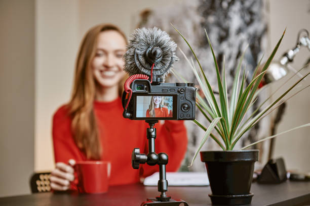 istock Creating content. Cheerful female blogger making a new video for her vlog and drinking a tea while sitting indoors. 1132090177