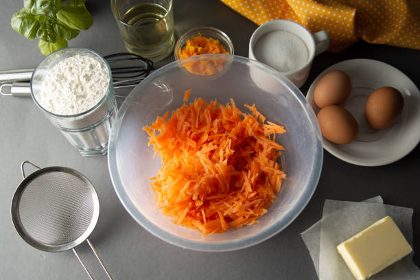istock Carrot cake recipe. Making dough for carrot cake, pie, muffins or tart, on kitchen table - eggs, flour, butter, orange, citrus, oil, sugar. Flat lay. Food, cake, pie recipe ingredients. 1132090194