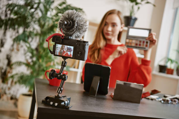 istock Beauty tips. Young attractive woman showing a makeup palette on camera while recording video review for her beauty blog 1132090229