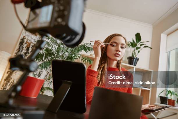 Evening Make Up Young Beauty Blogger With Brush And Eyeshadow Palette Looking At The Mirror While Recording Video At Home Stock Photo - Download Image Now